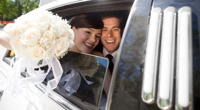Couple taking a perfect wedding ride in luxury car